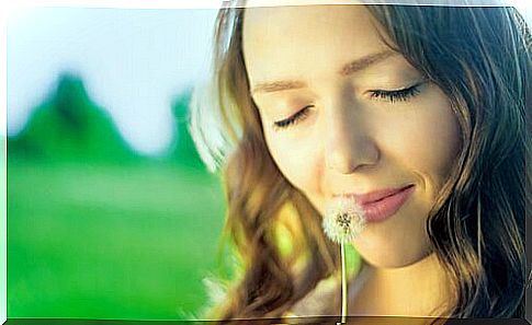 Woman smelling of dandelion.