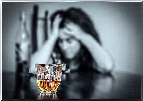 Depressed woman with a liquor glass in the foreground