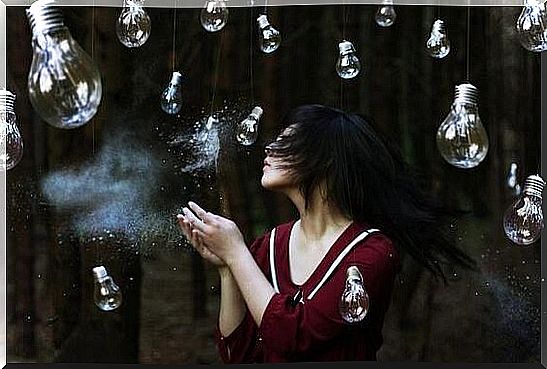 Woman standing among light bulbs.