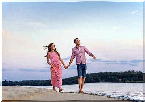 A couple walking together on a beach.