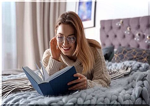 A woman who lives as a separate resident from her partner who lives at home and reads a book.