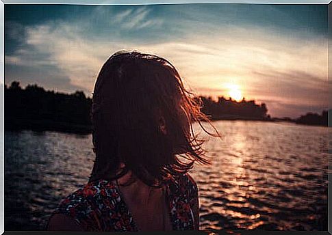 A woman looking back towards the sunset