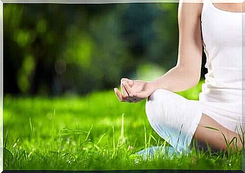 Woman meditating in the grass.